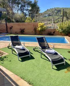 - deux chaises longues installées à côté de la piscine dans l'établissement Villa Belephant Sitges, à Canyelles