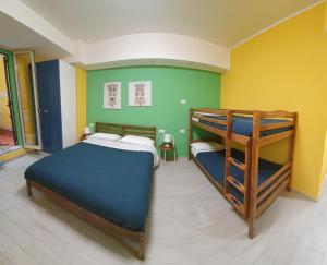 a bedroom with two bunk beds and yellow and green walls at Sicilia Bedda Taormina in Taormina