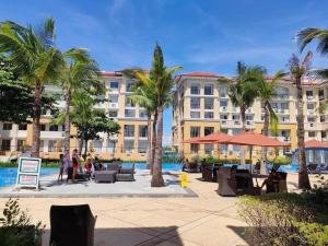 a resort with palm trees and a swimming pool at CasaMia Studio Sanremo Oasis Cebu in Talisay