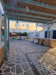 un patio al aire libre con suelo de piedra y techo de madera en Voula's Apartment, en Elafonisos