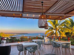 Un patio con mesas y sillas y vista al mar. en Hotel La Isla, en Puerto Ayora