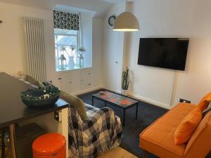 un soggiorno con divano e TV di Glen Ness Apartment in tranquil area of city centre a Inverness