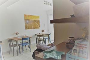 sala de estar con 2 mesas, mesa y sillas en Villa degli Alberi, en Buseto Palizzolo