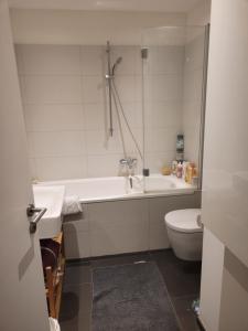 ein Badezimmer mit einer Badewanne, einem WC und einem Waschbecken in der Unterkunft 1 Zimmer App in Köln Ehrenfeld in Köln