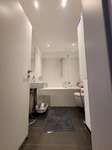 ein weißes Badezimmer mit einer Badewanne und einem Waschbecken in der Unterkunft 1 Zimmer App in Köln Ehrenfeld in Köln