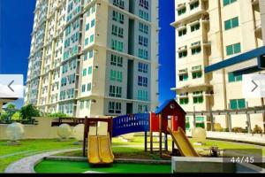 a playground with a slide in front of a tall building at San Lorenzo place condo in Manila