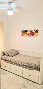 Bett in einem Zimmer mit einem Bild an der Wand in der Unterkunft Apartamento a 2 minutos de la playa y centro in Fuengirola