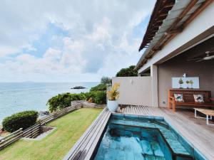 a house with a swimming pool and a view of the ocean at Luxury beachfront villa with private pool - Jolly's Rock in Calodyne
