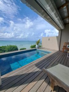 a deck with a swimming pool and a view of the ocean at Luxury beachfront villa with private pool - Jolly's Rock in Calodyne