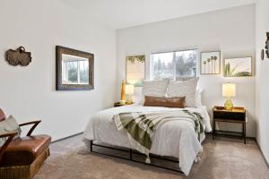 a white bedroom with a bed and two windows at HUGE-Fun-Trendy Apt by Perry District & Downtown in Spokane