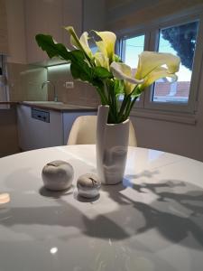 un jarrón de flores amarillas sentado sobre una mesa en Holiday home Paula, en Radovići