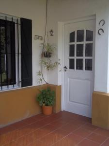 a front door of a house with potted plants at La Colonial Cabañas in Villa Cura Brochero