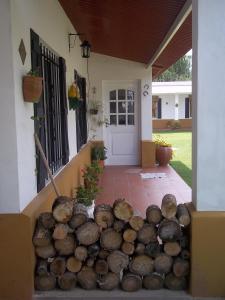 uma pilha de troncos em frente a uma casa em La Colonial Cabañas em Villa Cura Brochero