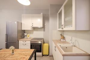 a kitchen with white cabinets and a stainless steel refrigerator at Elegance Studio Apartments in Zadar