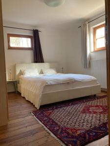 ein Schlafzimmer mit einem Bett und einem Teppich und zwei Fenstern in der Unterkunft Haus Renate 