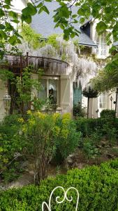 uma casa com um jardim com um banco em frente em Chambres d'hôtes Jardin D'ivoire em Saint-Gervais-la-Forêt