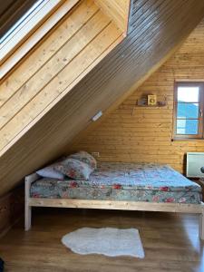 a bed in a room with a wooden wall at Zemene in Bauska