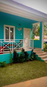 uma casa azul com um alpendre e escadas em Stan-Inn, North Goa, Vagator, with strong WIFI,free private parking & kitchen, Can Cook where you stay em Vagator