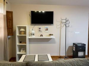 sala de estar con TV de pantalla plana en la pared en Habitación con encanto, en Granada