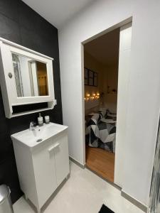 a white bathroom with a sink and a bedroom at Habitación con encanto in Granada
