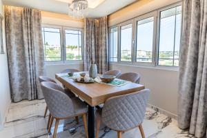 a dining room with a table and chairs and windows at Thomas Villa Hersonissos - Private Pool - Sleeps 7 in Hersonissos
