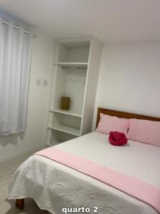 um quarto com uma cama com um bicho de peluche vermelho em Condomínio novíssimo com total estrutura para vc em Arraial do Cabo
