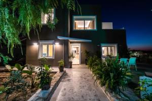 a house with a courtyard at night at Thomas Villa Hersonissos - Private Pool - Sleeps 7 in Hersonissos