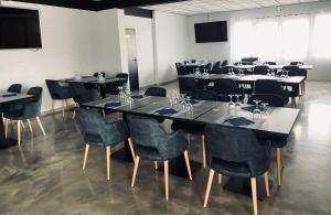 une salle à manger avec des tables, des chaises et un écran dans l'établissement Domaine de la Mer, à Woignarue