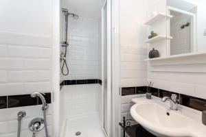 baño blanco con ducha y lavamanos en Guest House VATICAN MUSEUMS PARVA DOMUS, en Roma