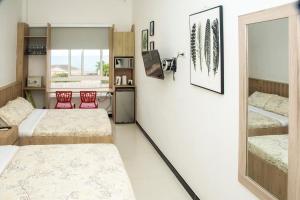 Habitación con 2 camas y cocina con 2 sillas rojas. en Apartamento Ganem 505a en Cartagena de Indias