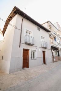 una casa bianca con una porta marrone su una strada di Apartamentos Turísticos A Tu Verita a Jaraiz de la Vera