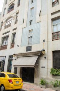 żółty samochód zaparkowany przed budynkiem w obiekcie Apartamento Ganem 505a w mieście Cartagena de Indias
