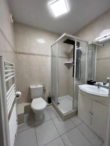 een badkamer met een douche, een toilet en een wastafel bij Kimi Résidence in Cannes