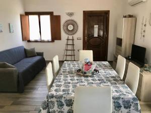 a living room with a table and a blue couch at casa indipendente con accesso diretto al mare in Ovile la Marina