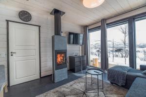 a living room with a fireplace and a couch at Korppi Mökki in Kilpisjärvi