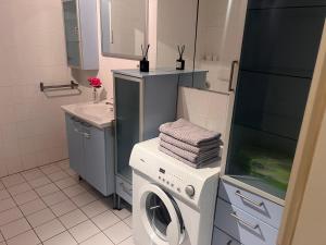 ein Badezimmer mit einer Waschmaschine und einem Waschbecken in der Unterkunft casabella in Leverkusen