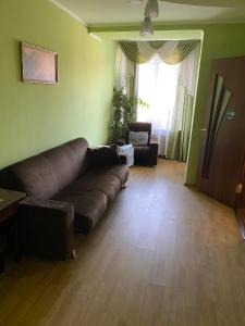 un soggiorno con divano marrone e finestra di Готель Корнет a Umanʼ