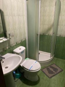 a bathroom with a toilet and a sink and a shower at Готель Корнет in Umanʼ