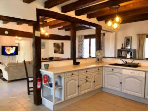 une grande cuisine avec des placards blancs et un salon dans l'établissement Maison Lavande le grande gite, à Menetou-sur-Nahon