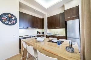 a kitchen with a wooden table and a clock on the wall at Thomas House Hersonissos - Private Pool - Sleeps 6 in Hersonissos