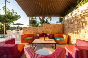 a patio with a table and chairs and a stone wall at Thomas House Hersonissos - Private Pool - Sleeps 6 in Hersonissos