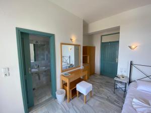 a bedroom with a bathroom with a sink and a mirror at Hotel Plakures in Falasarna
