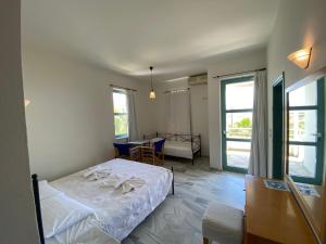 a bedroom with a bed and a table and chairs at Hotel Plakures in Falasarna