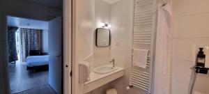 a white bathroom with a sink and a mirror at Hotel De L'Europe in Perros-Guirec +37 photos