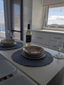 una mesa con dos platos y una botella de vino en Infinity Blue Suite, en Panteli