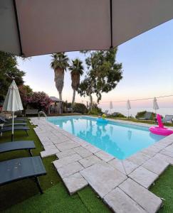 - une piscine avec des chaises et un parasol dans l'établissement Residence VILLA MOROSI - Favone, à Conca