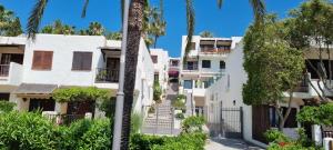 una fila di edifici di appartamenti bianchi con palme di Apartamento 309 frente al mar en Alcossebre ad Alcossebre
