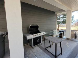 a grill on a patio with a table and a stool at Lakeview in Peachland