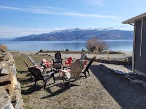 a group of chairs and a table in front of a lake at Lakeview in Peachland