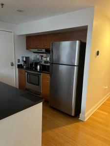 uma cozinha com um frigorífico de aço inoxidável e armários de madeira em Full loft apartment near Omni Hotel em New Haven